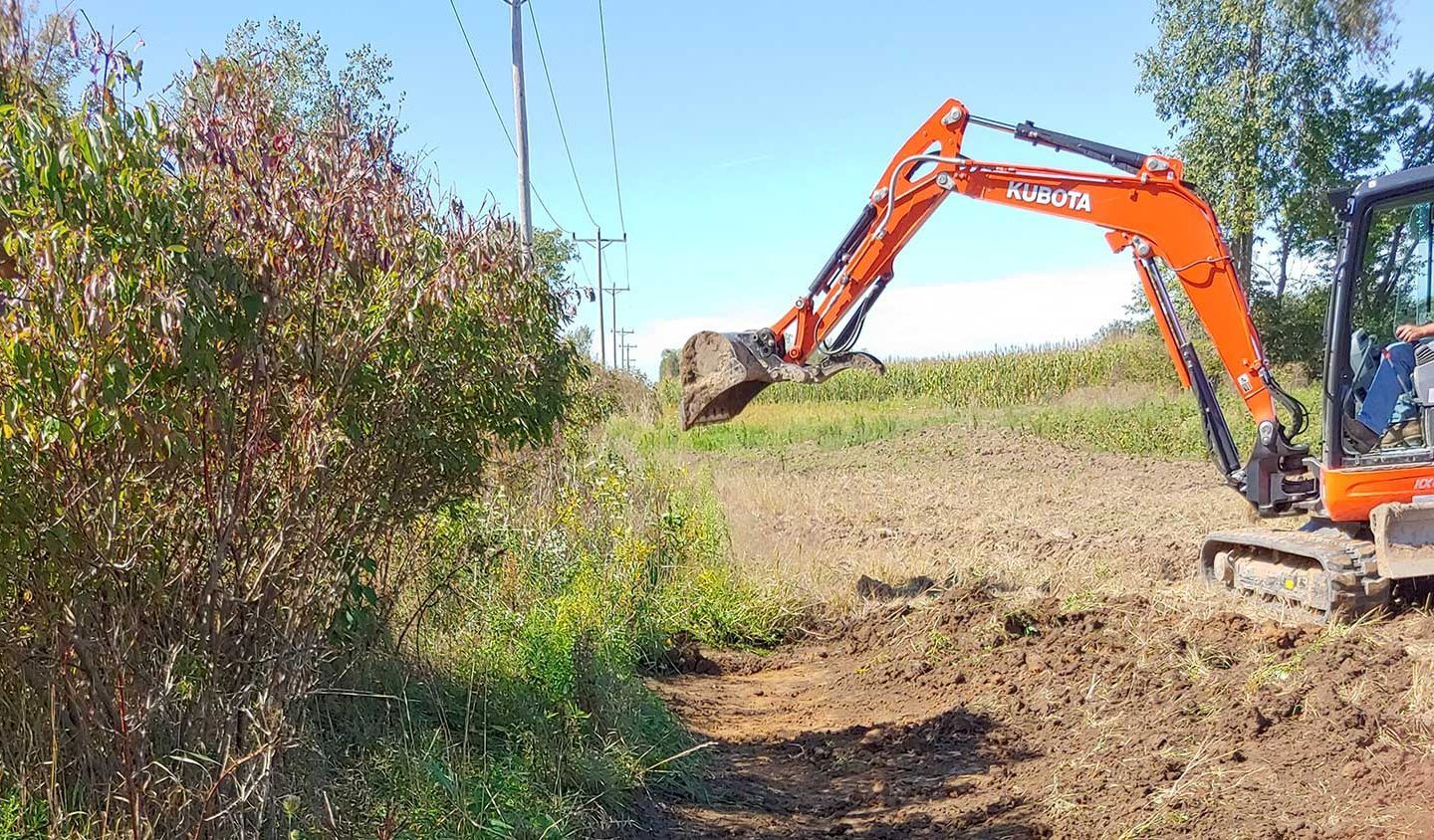 orange excavator on brown dirt field during daytime