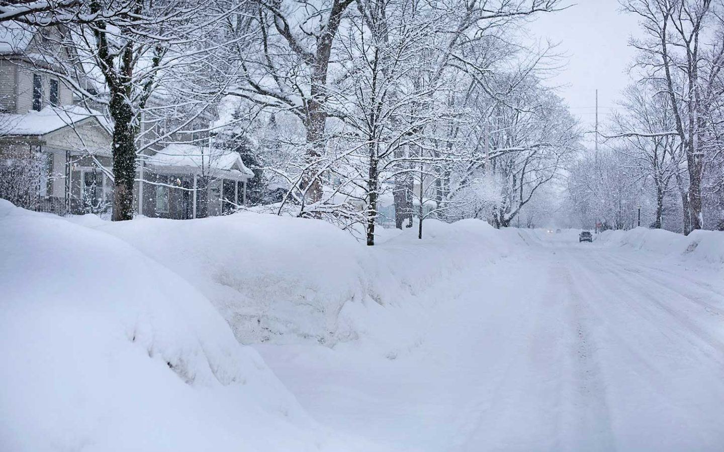 snow covered road in a neighbourhood during daytime
