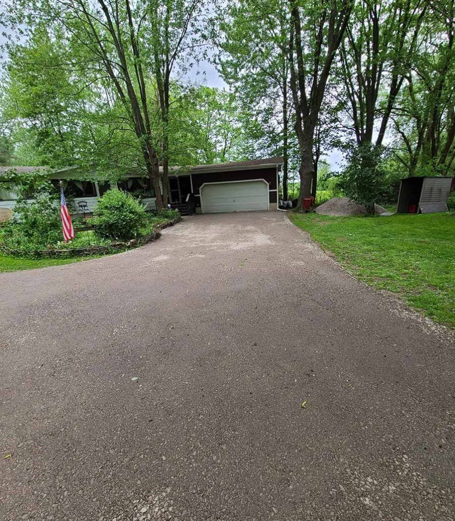 a long gravel driveway leading up to a house