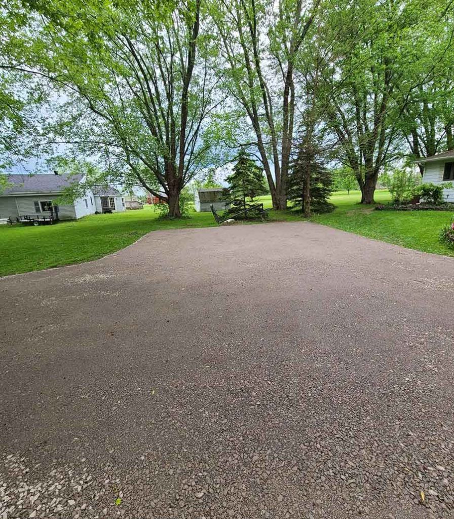 a long gravel driveway leading up to a house