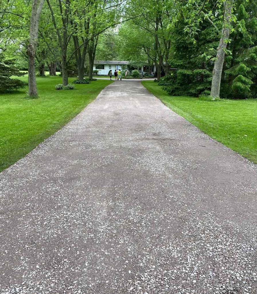 a long gravel driveway leading up to a house