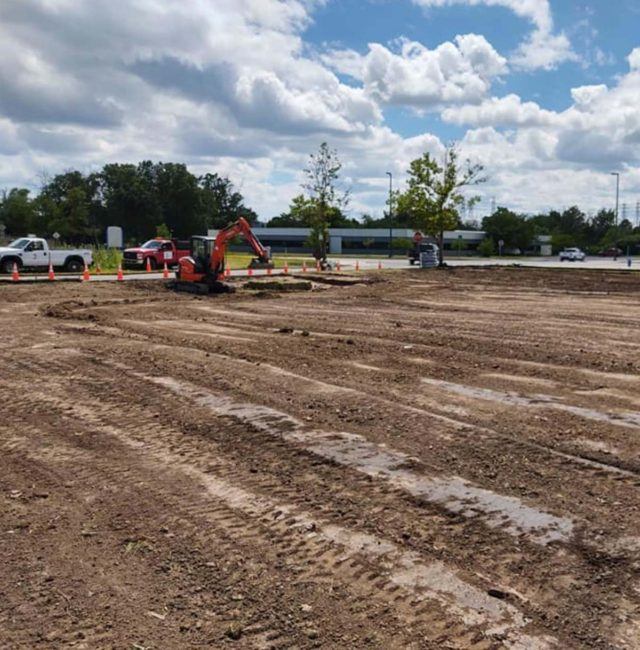 construction vehicles onsite clearing out a dirt field