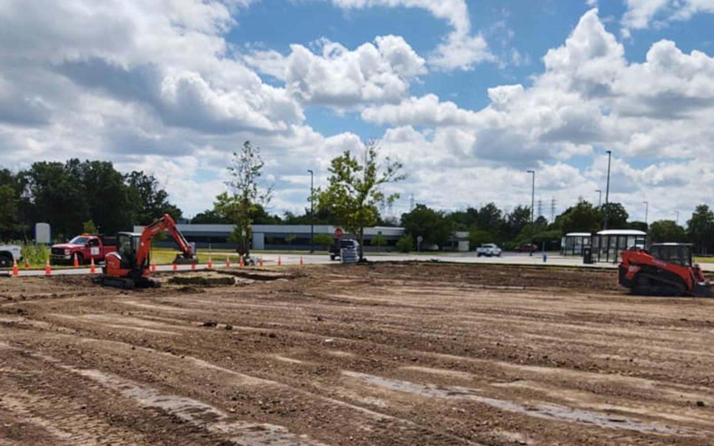 construction vehicles onsite clearing out a dirt field