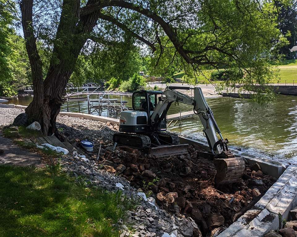 a digger digging next to a waterway