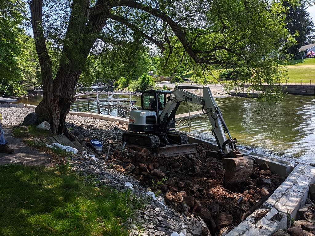 a digger digging next to a waterway