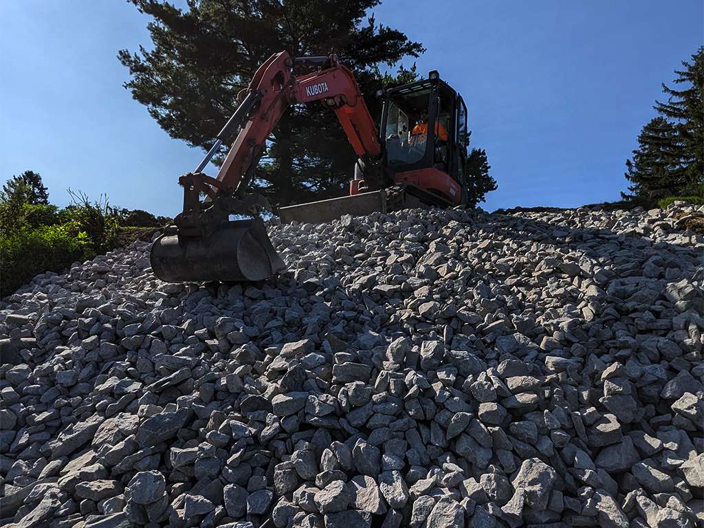 a jcb scooping up rocks