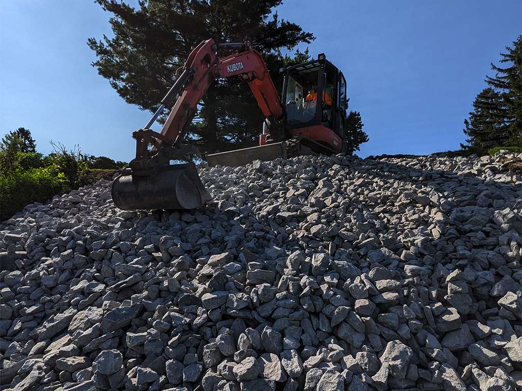 a jcb scooping up rocks