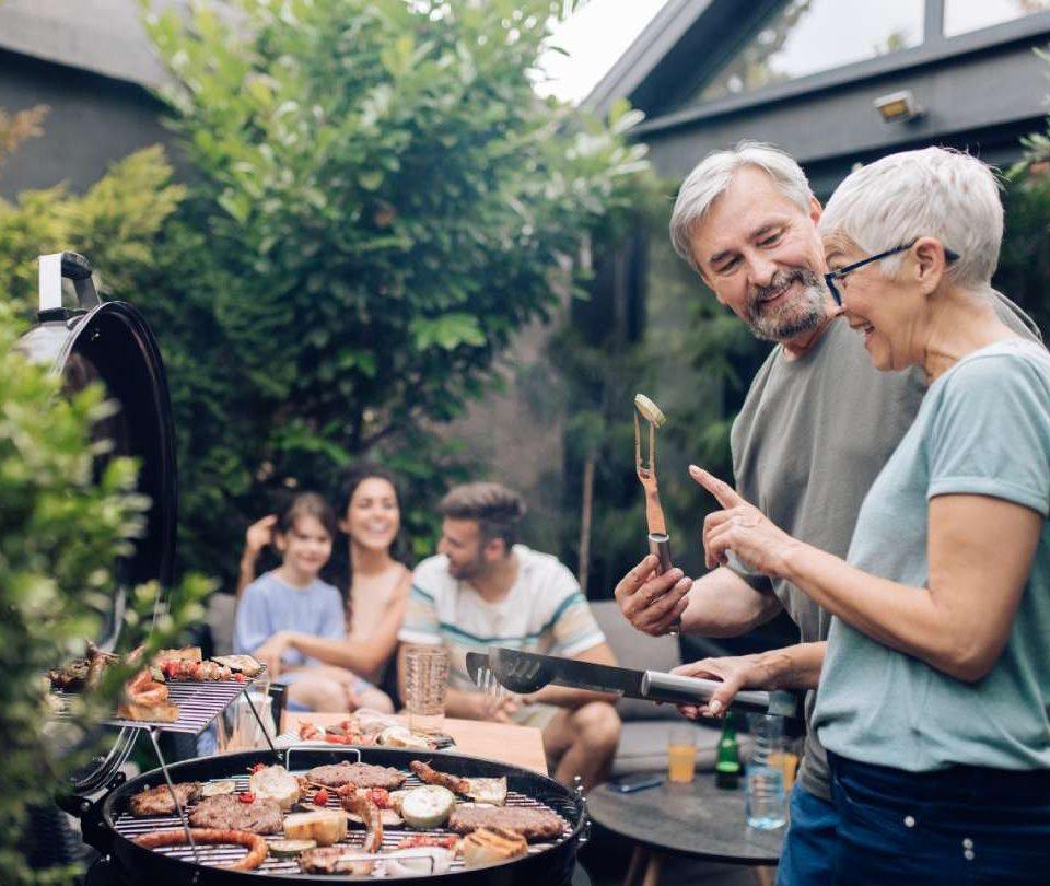 a man and woman grilling food on a grill