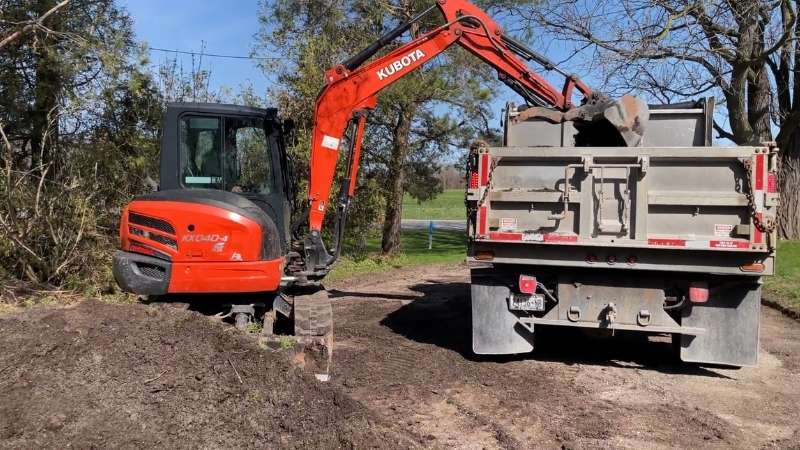 a tractor is parked next to a dump truck